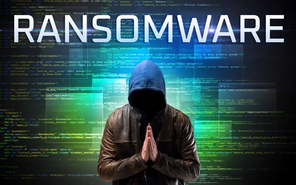 man with hood praying with ransomware word on top of him