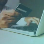 Image of someone typing on a laptop while holding a credit card